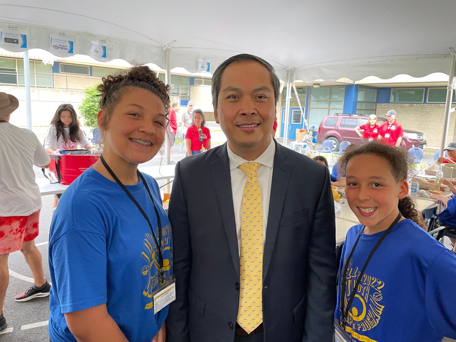 A man in a suit and tie is posing for a picture with two girls.