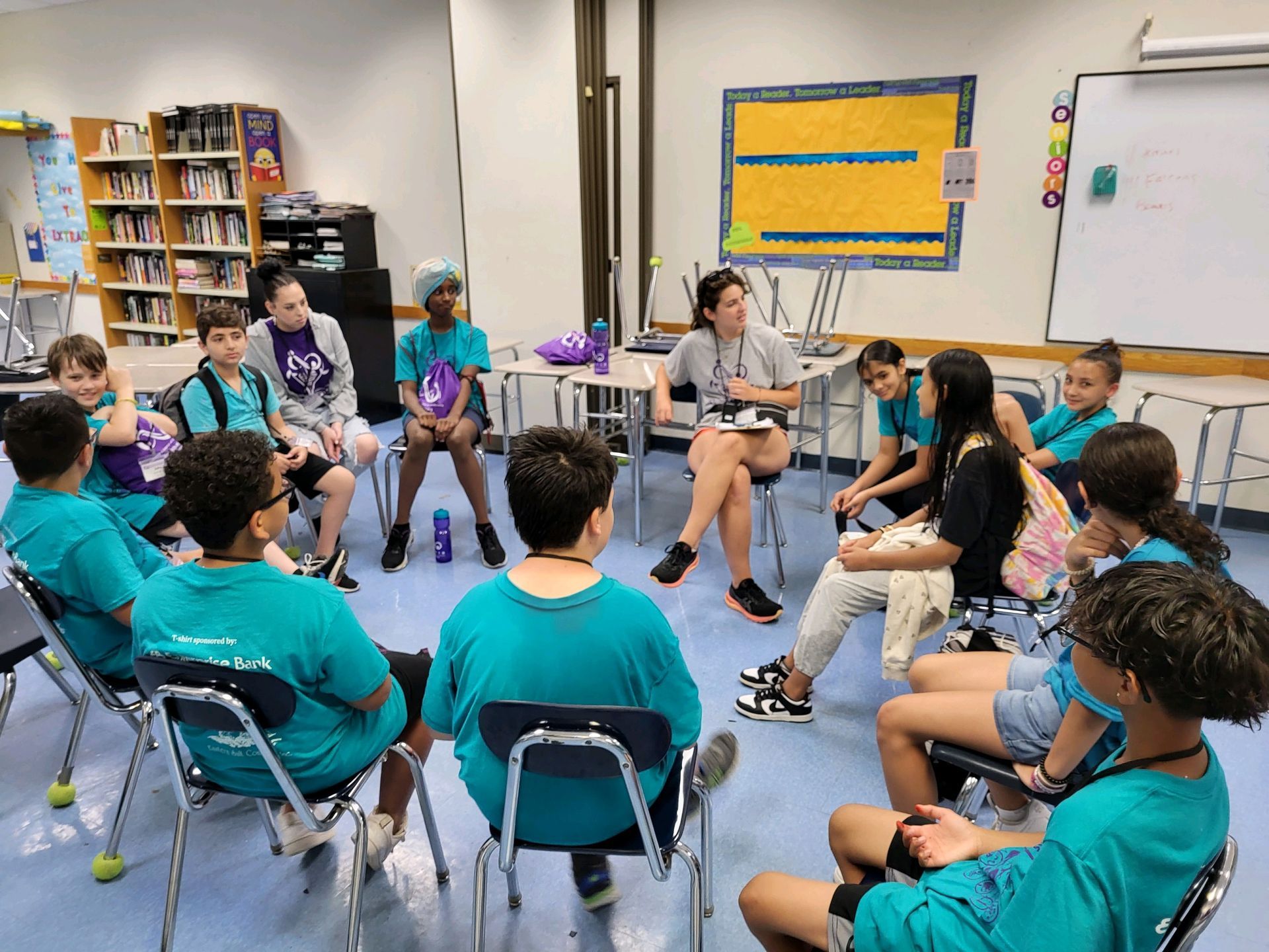 A group of children are sitting in a circle in a classroom.