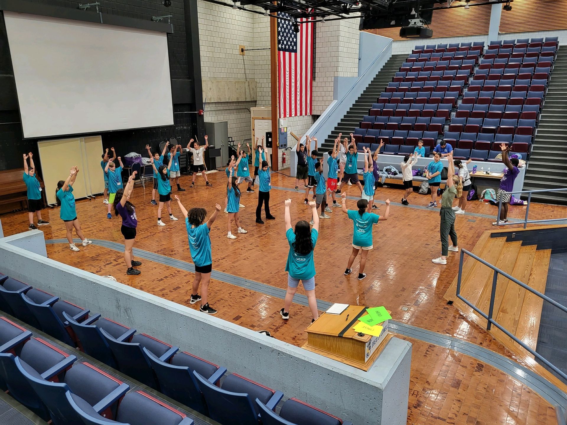 A group of people are standing on a stage with their arms in the air.