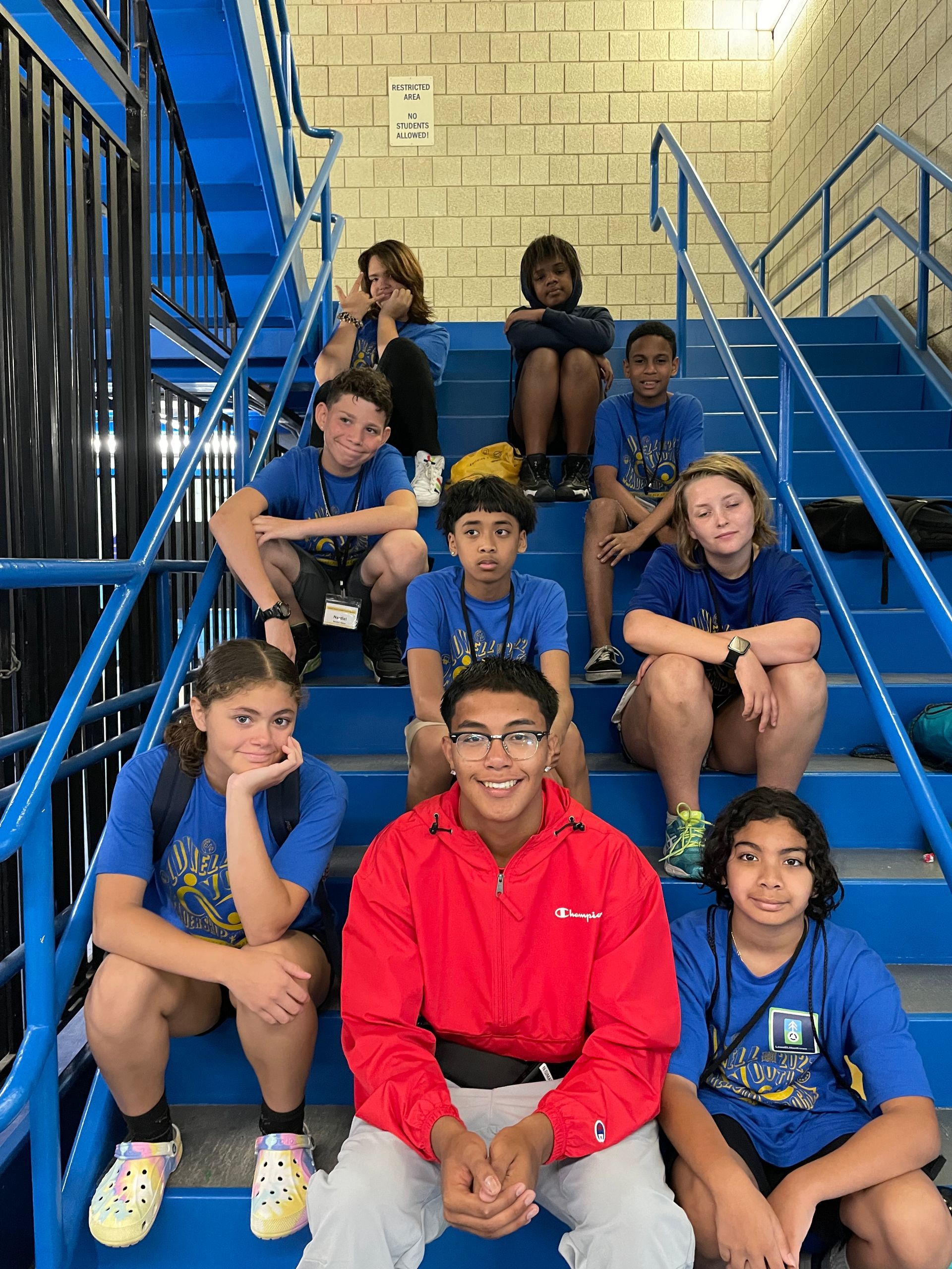 A group of children are sitting on a set of blue stairs.