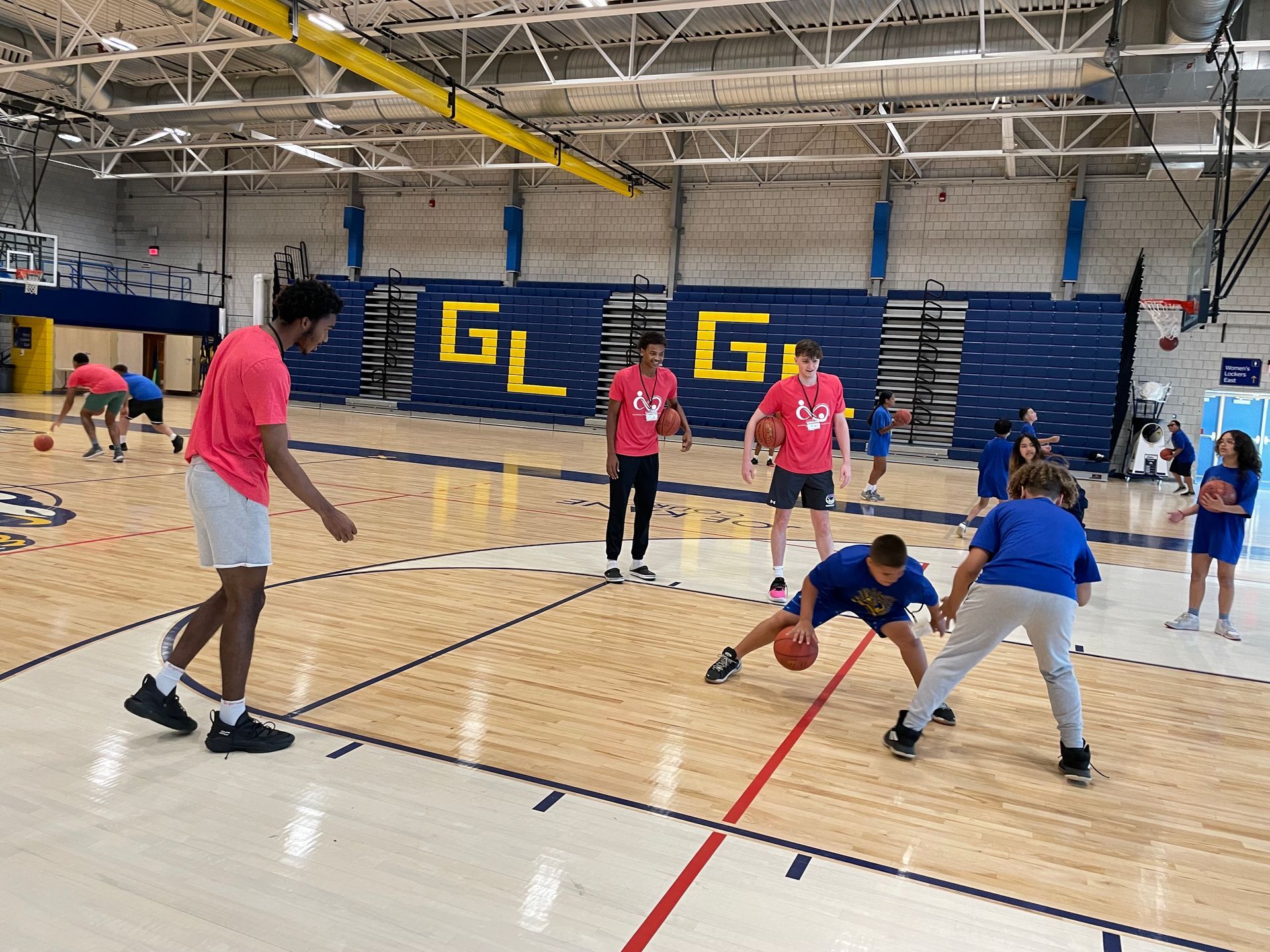 A group of people are playing basketball in a gym.