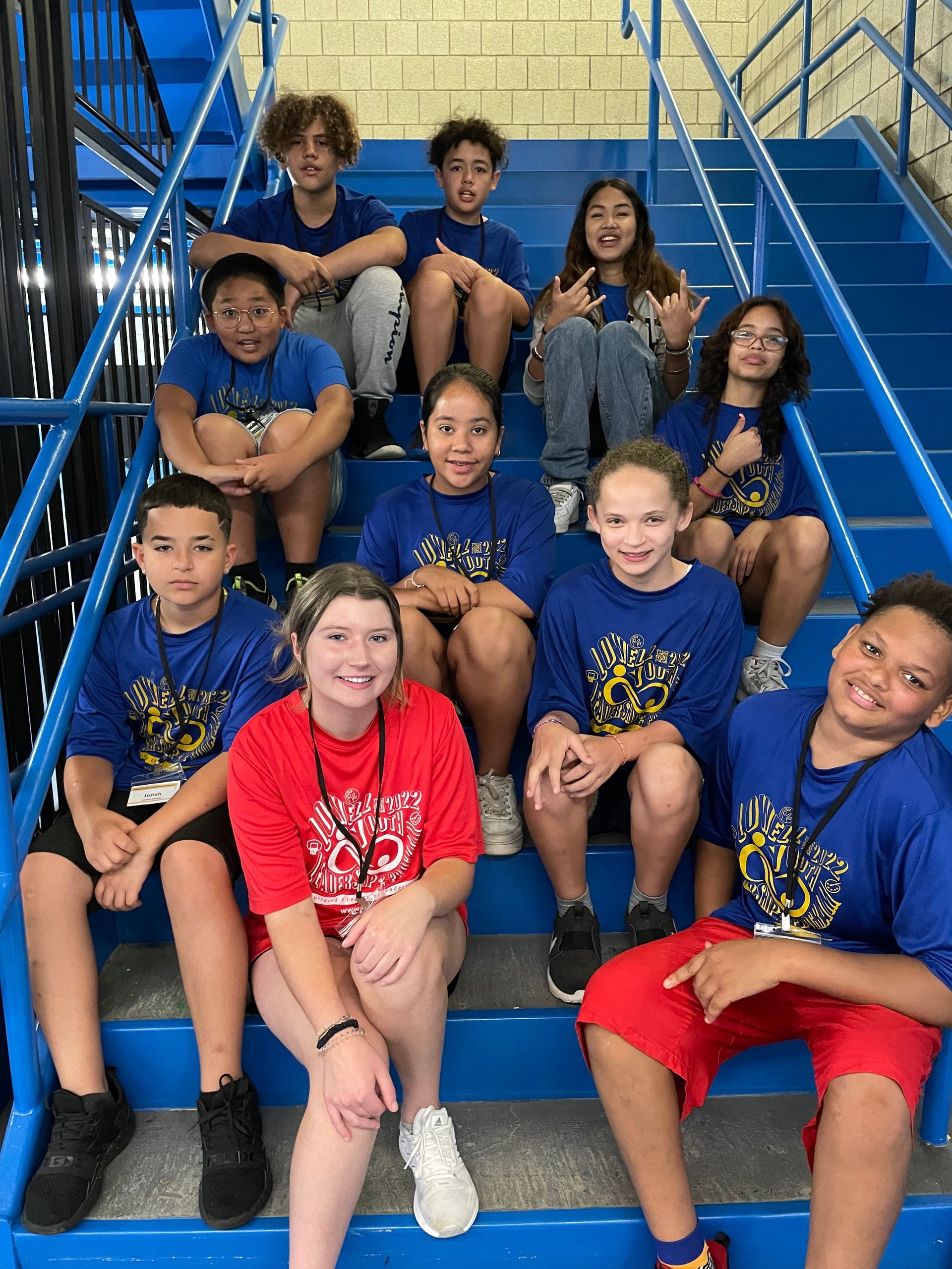 A group of children are sitting on a set of blue stairs.