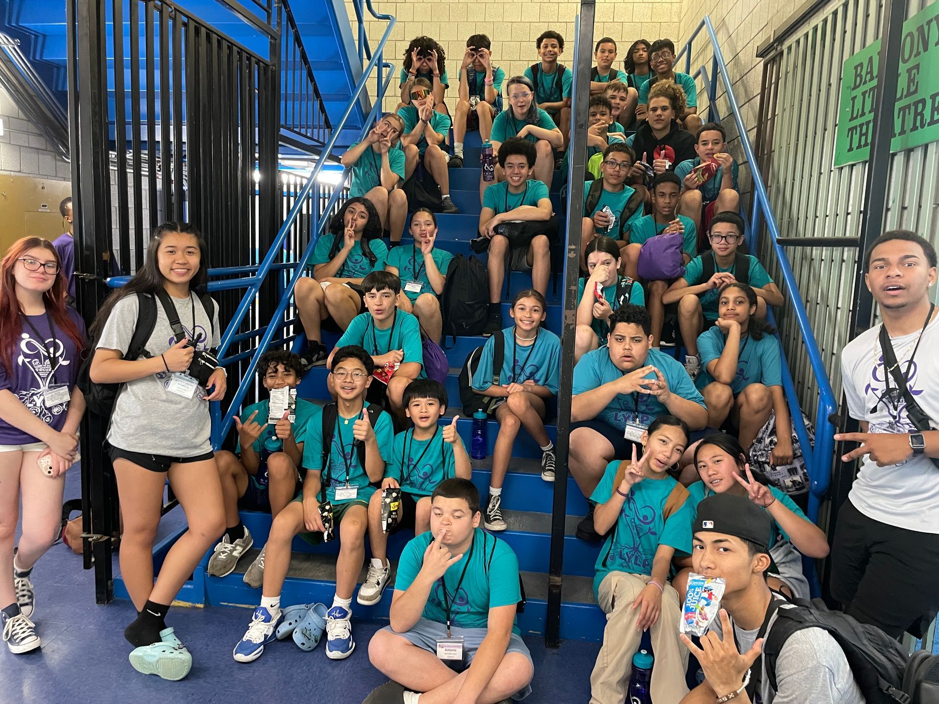 A group of young people are sitting on a set of stairs.