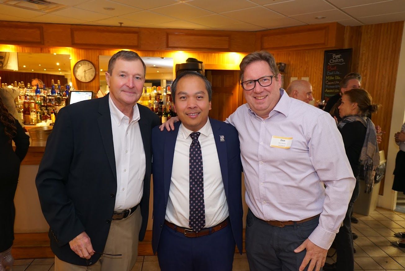 Three men are posing for a picture together in a room.