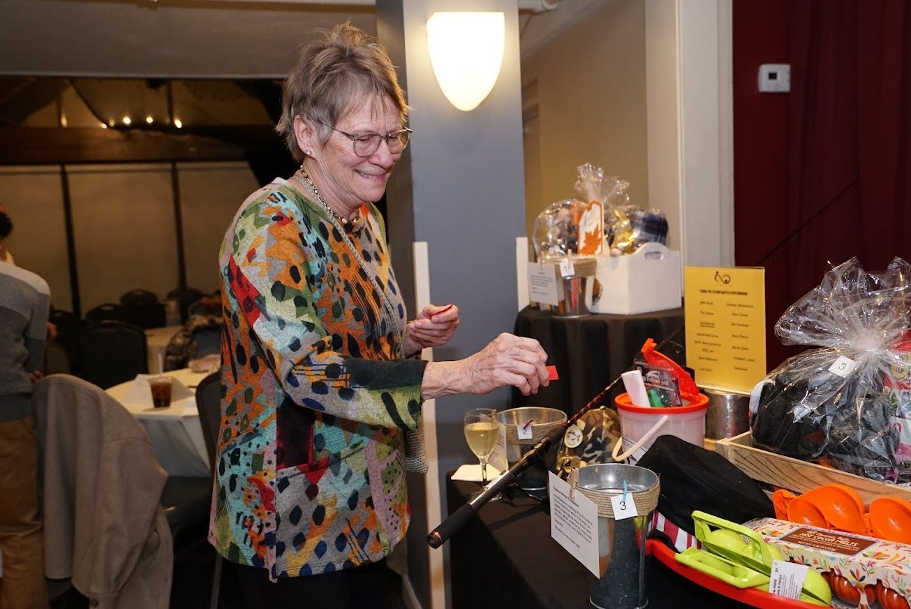 A woman is standing in front of a table with a lot of items on it.