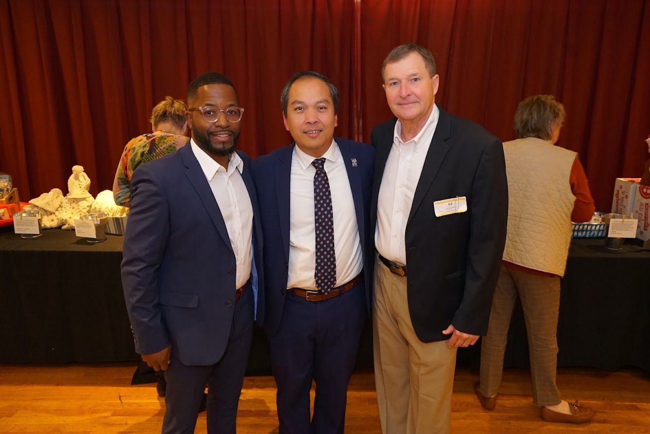 Three men in suits and ties are posing for a picture.