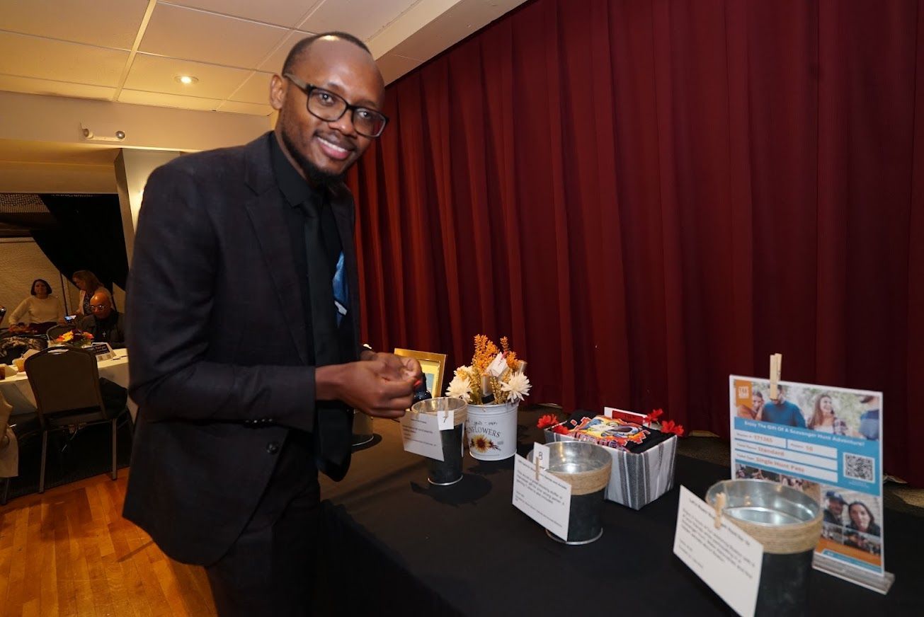 A man in a suit and tie is standing in front of a table.