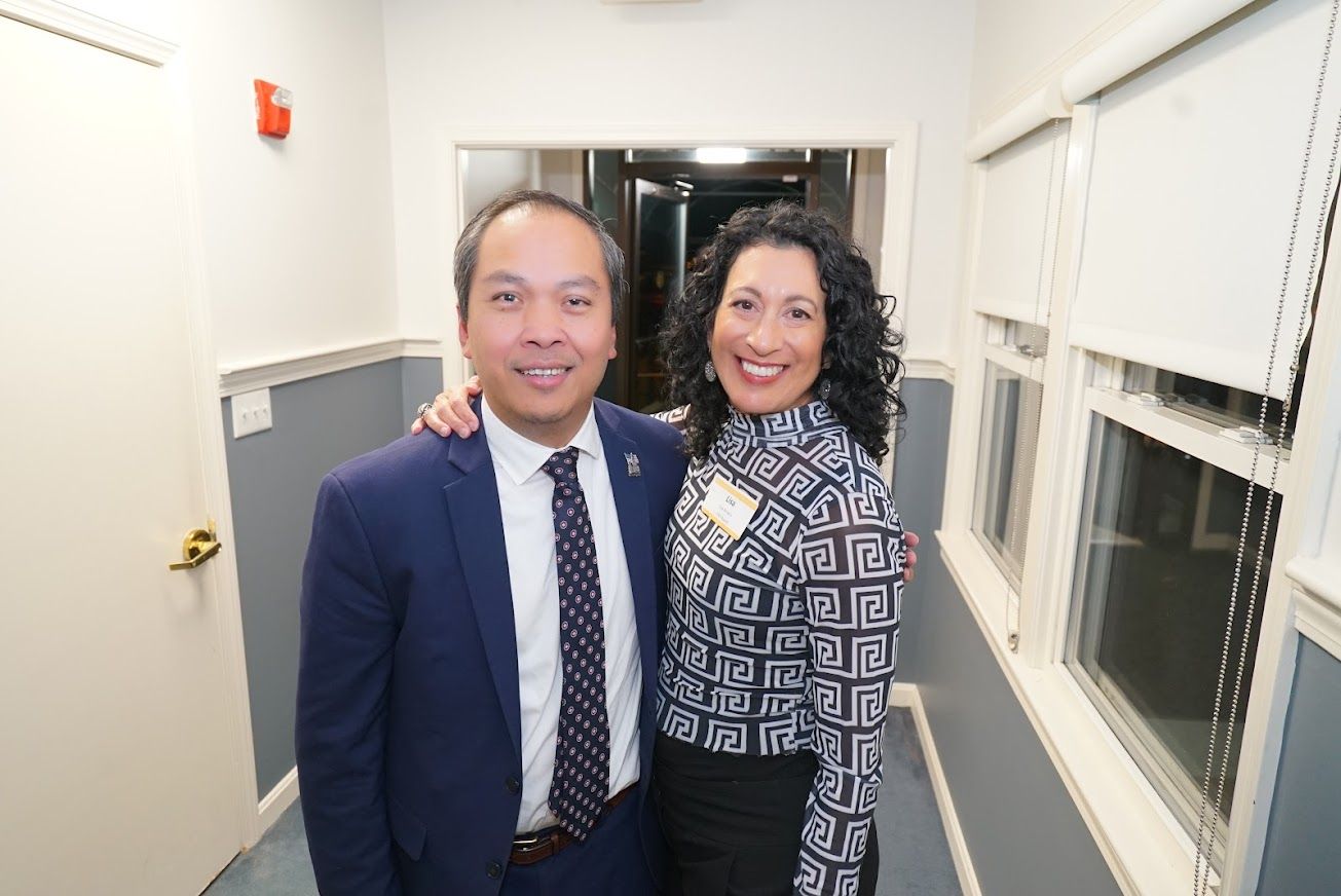 A man and a woman are posing for a picture in a hallway.