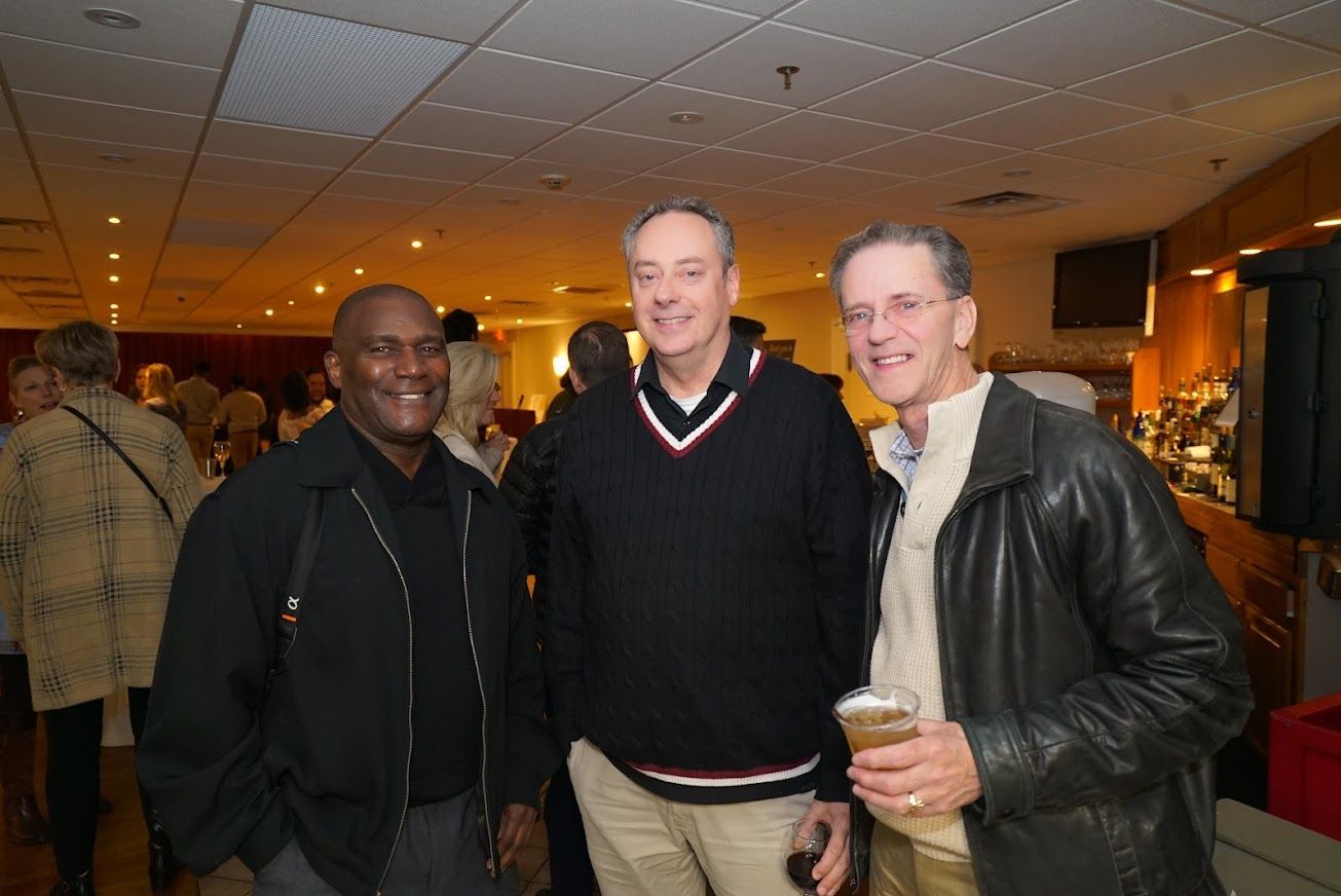 Three men are posing for a picture in a room