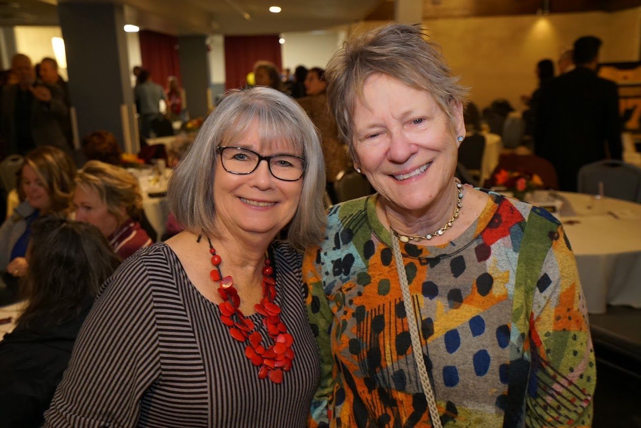 Two women are posing for a picture together at a party.