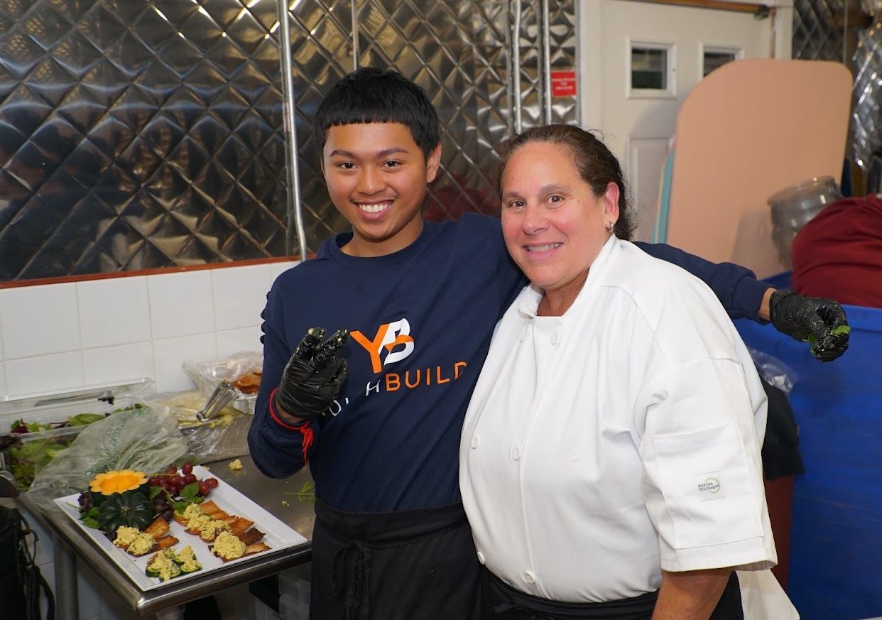 A boy wearing a y3 sweatshirt stands next to a woman