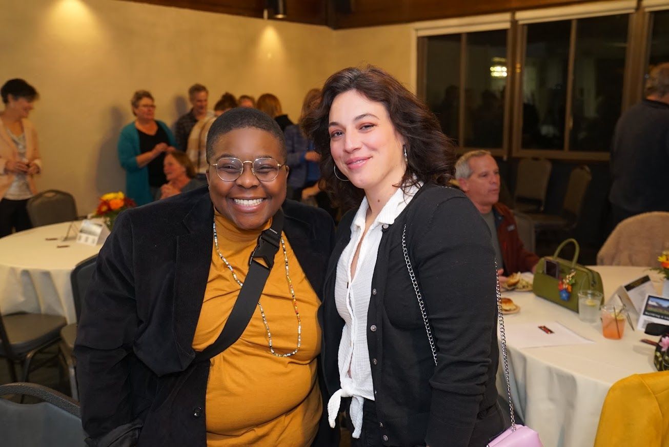 Two women are posing for a picture in a room