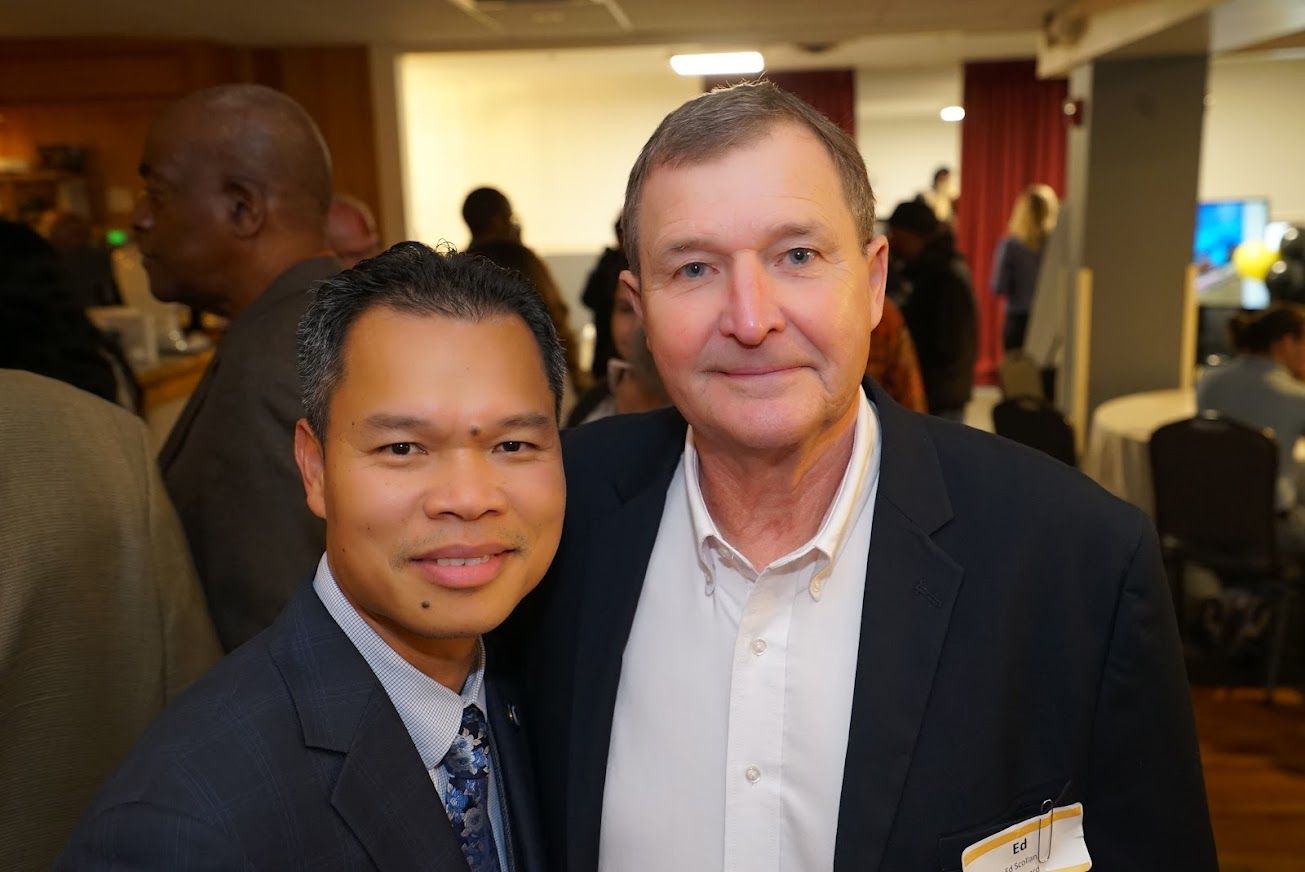 Two men are posing for a picture together in a room.