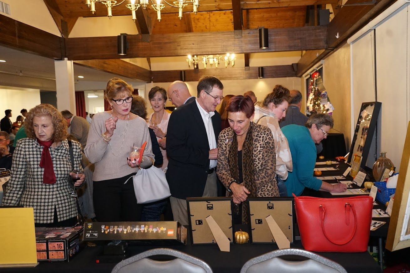 A group of people are standing around a table in a room.