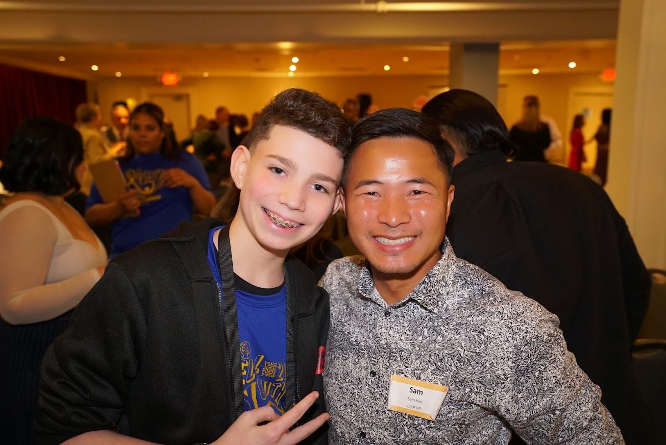 Two men are posing for a picture together at a party.