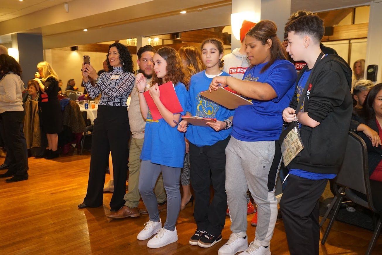 A group of young people are standing in a room.