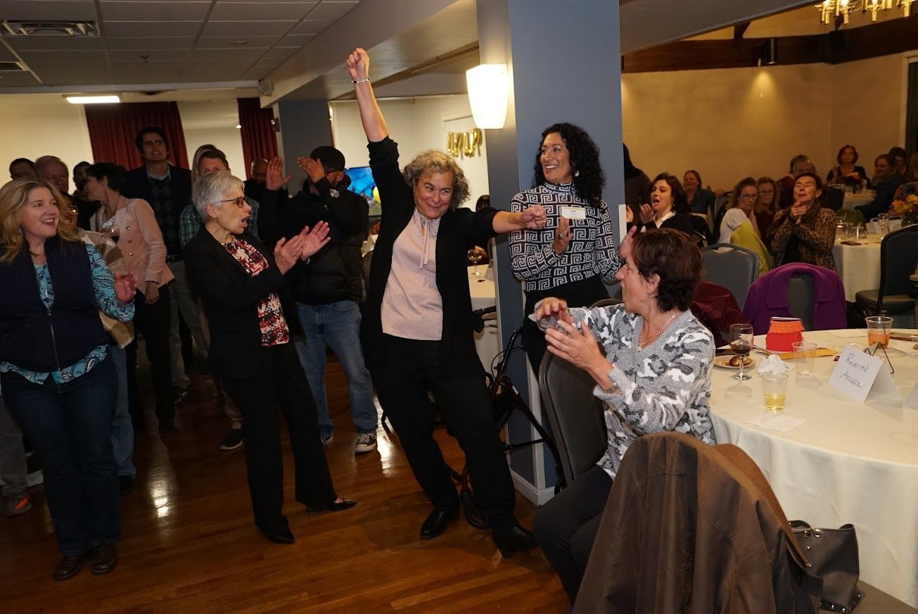 A group of people are dancing in a room.