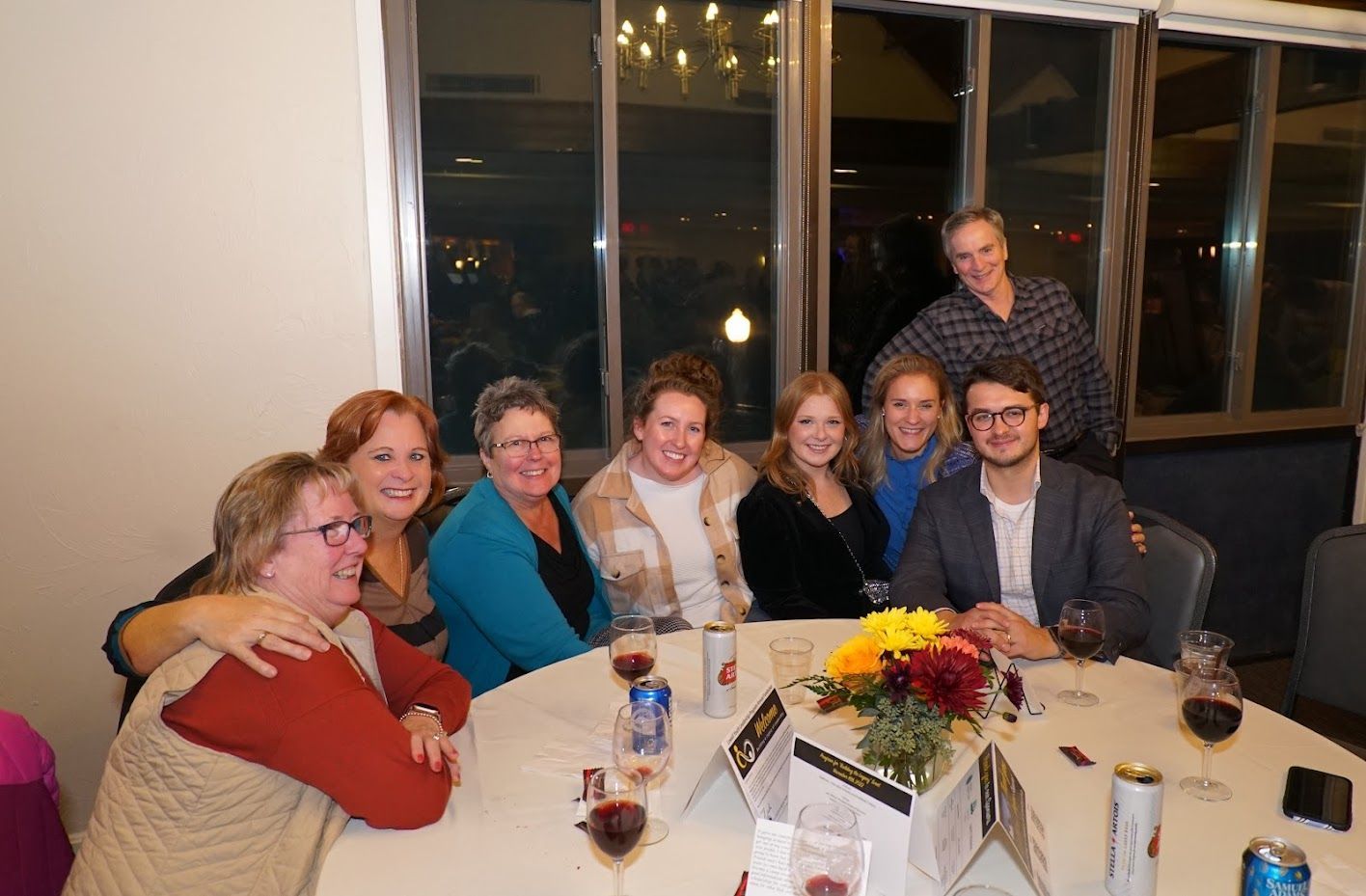 A group of people are sitting around a table with wine glasses.