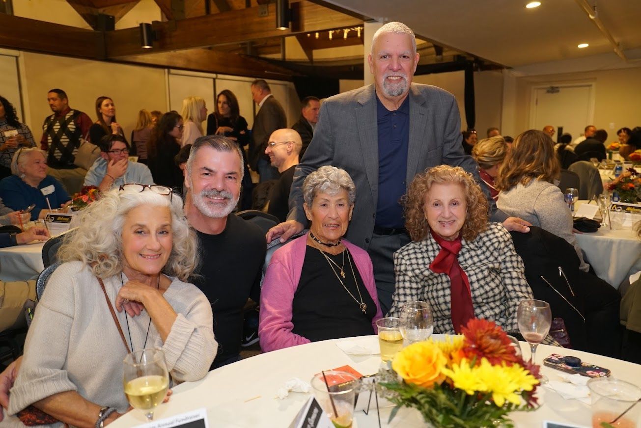 A group of people are posing for a picture at a table.