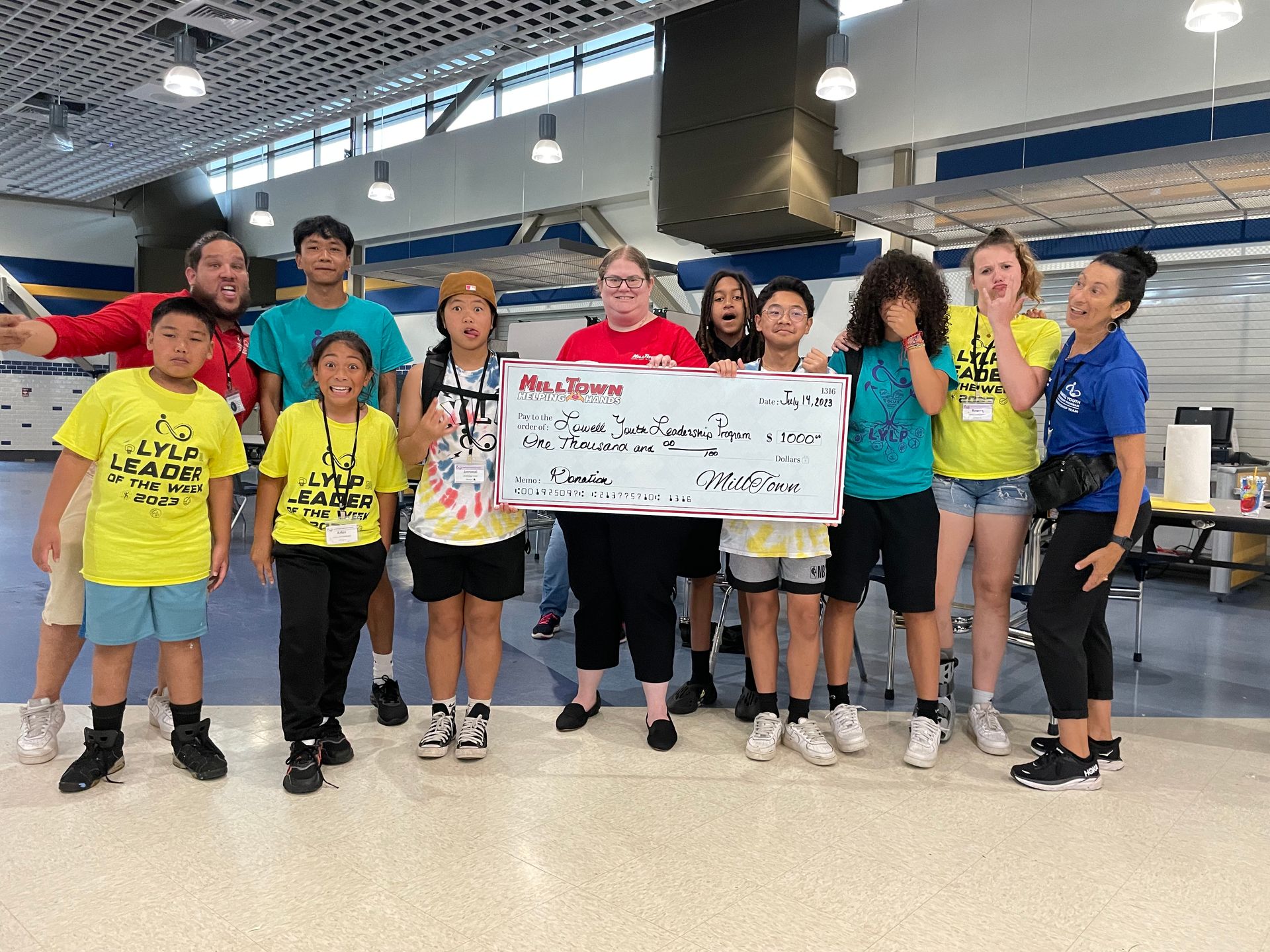 A group of children are posing for a picture while holding a large check.