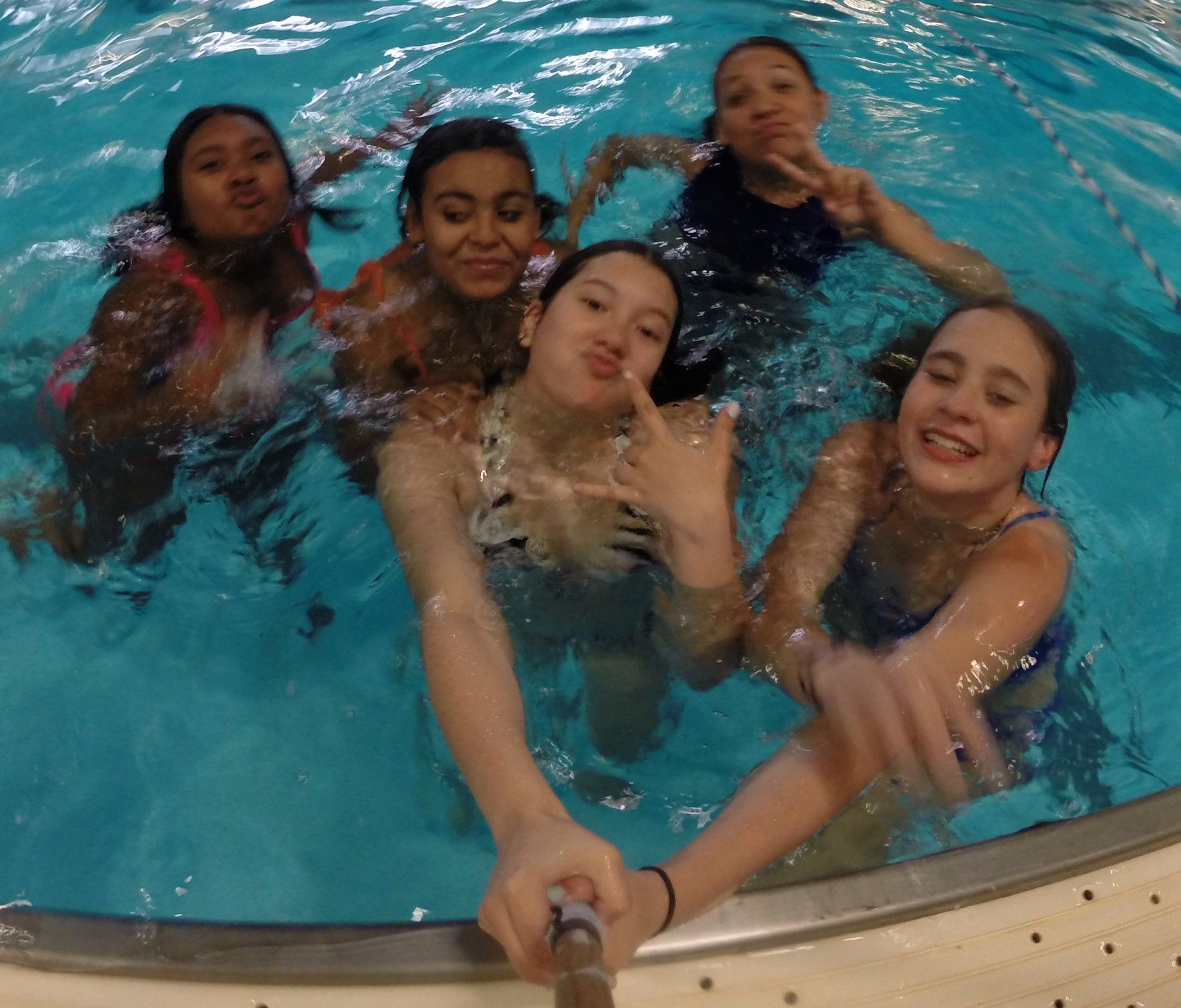 A group of girls are taking a selfie in a swimming pool