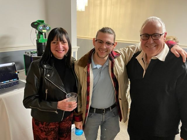 A man and two women are posing for a picture together