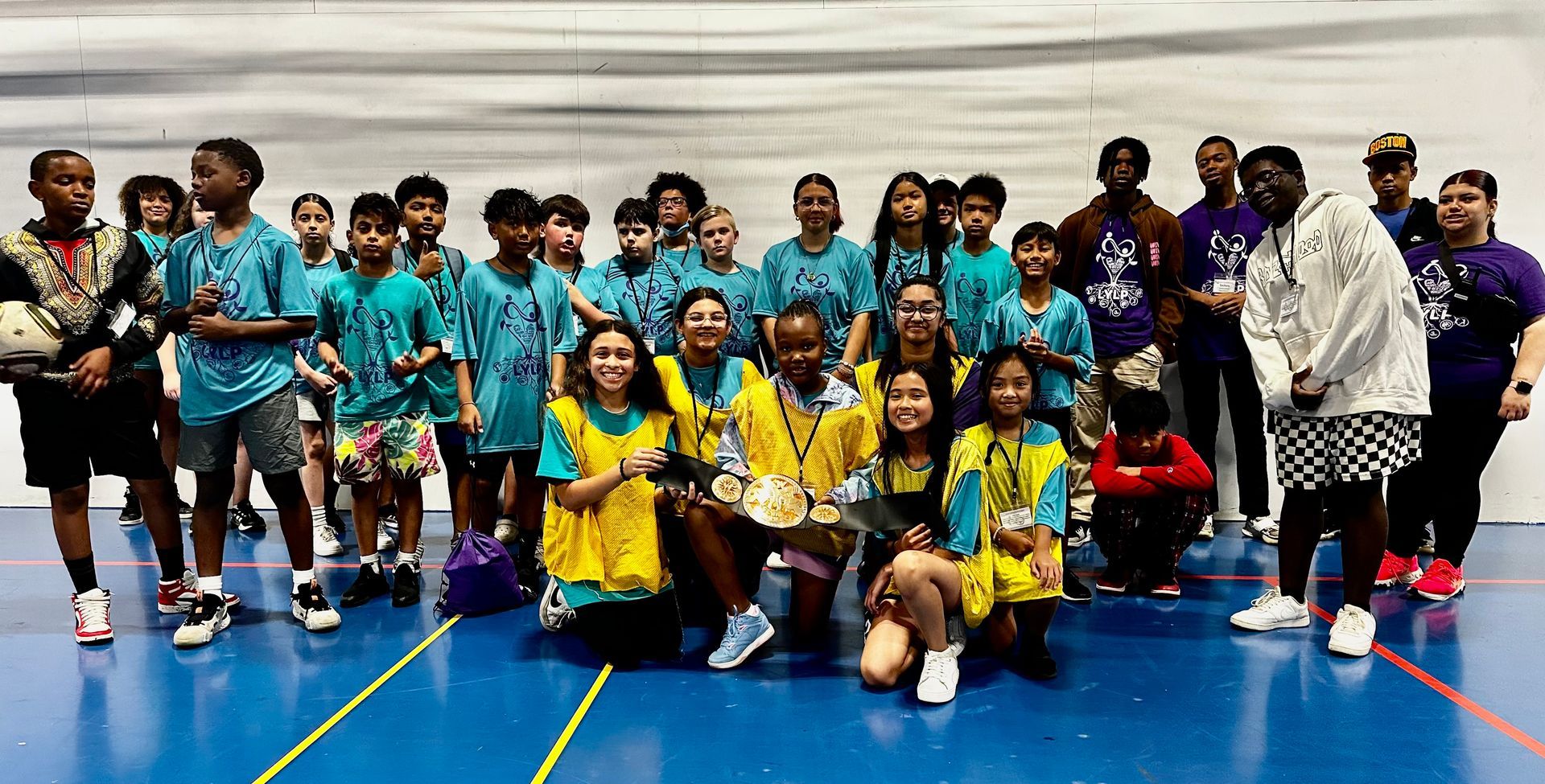 A group of young people are posing for a picture in a gym.