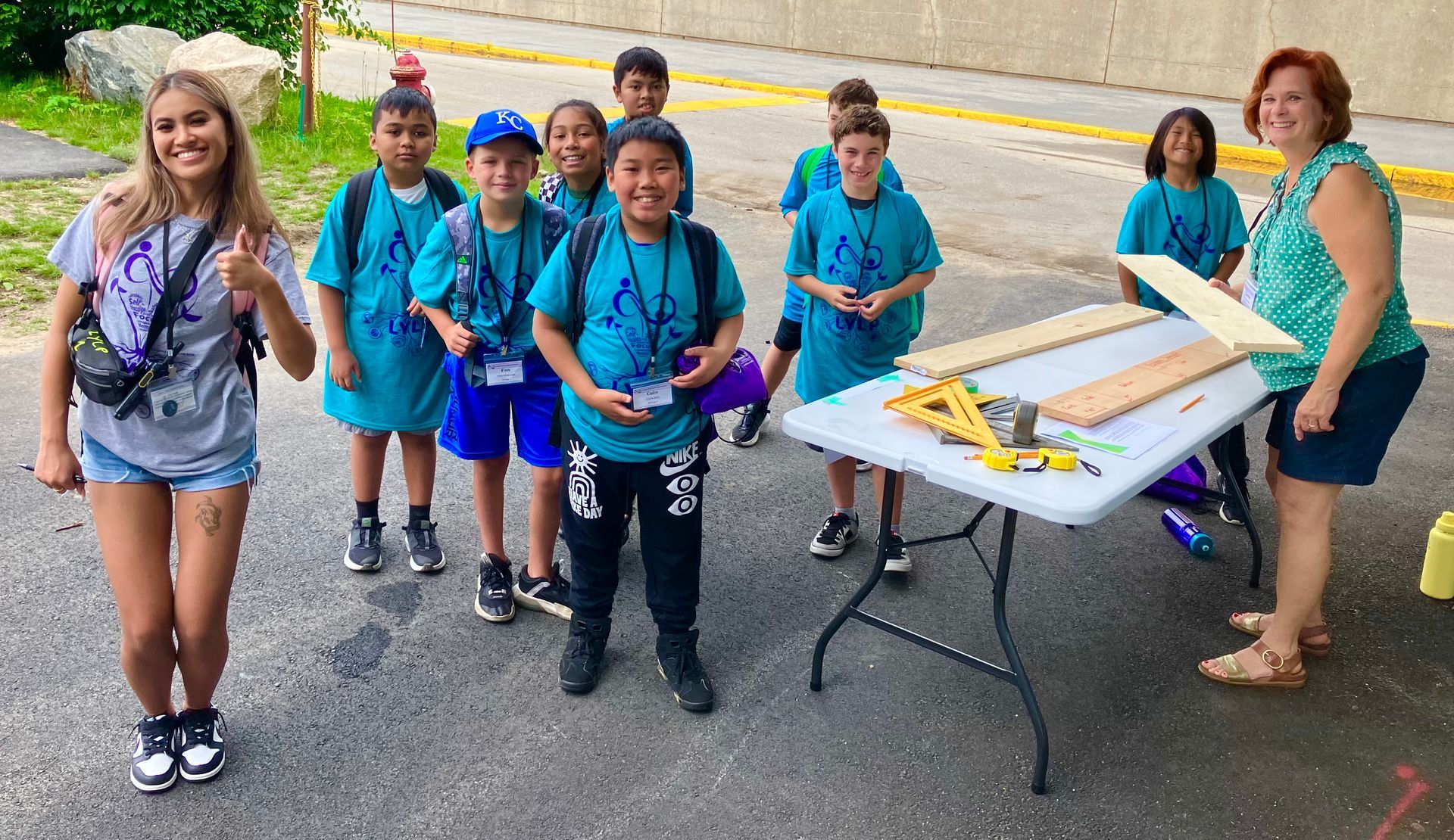 A group of children are standing in front of a table.