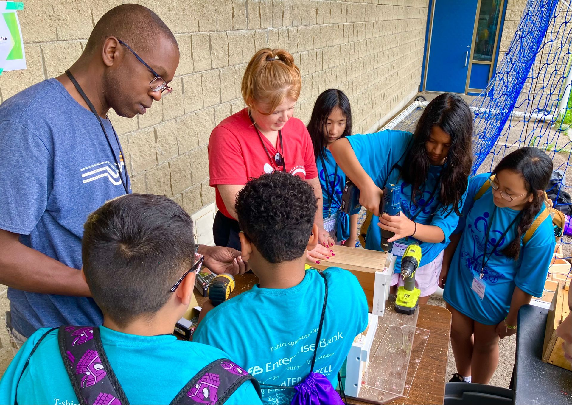 A group of children are working on a project with a teacher.