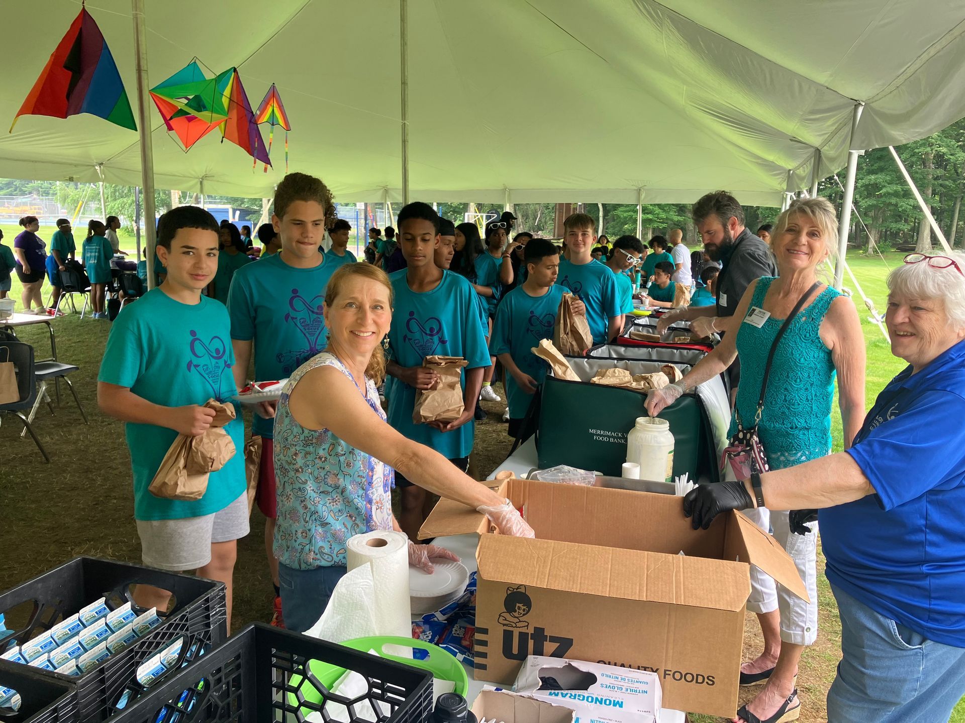 A group of people are standing under a tent.