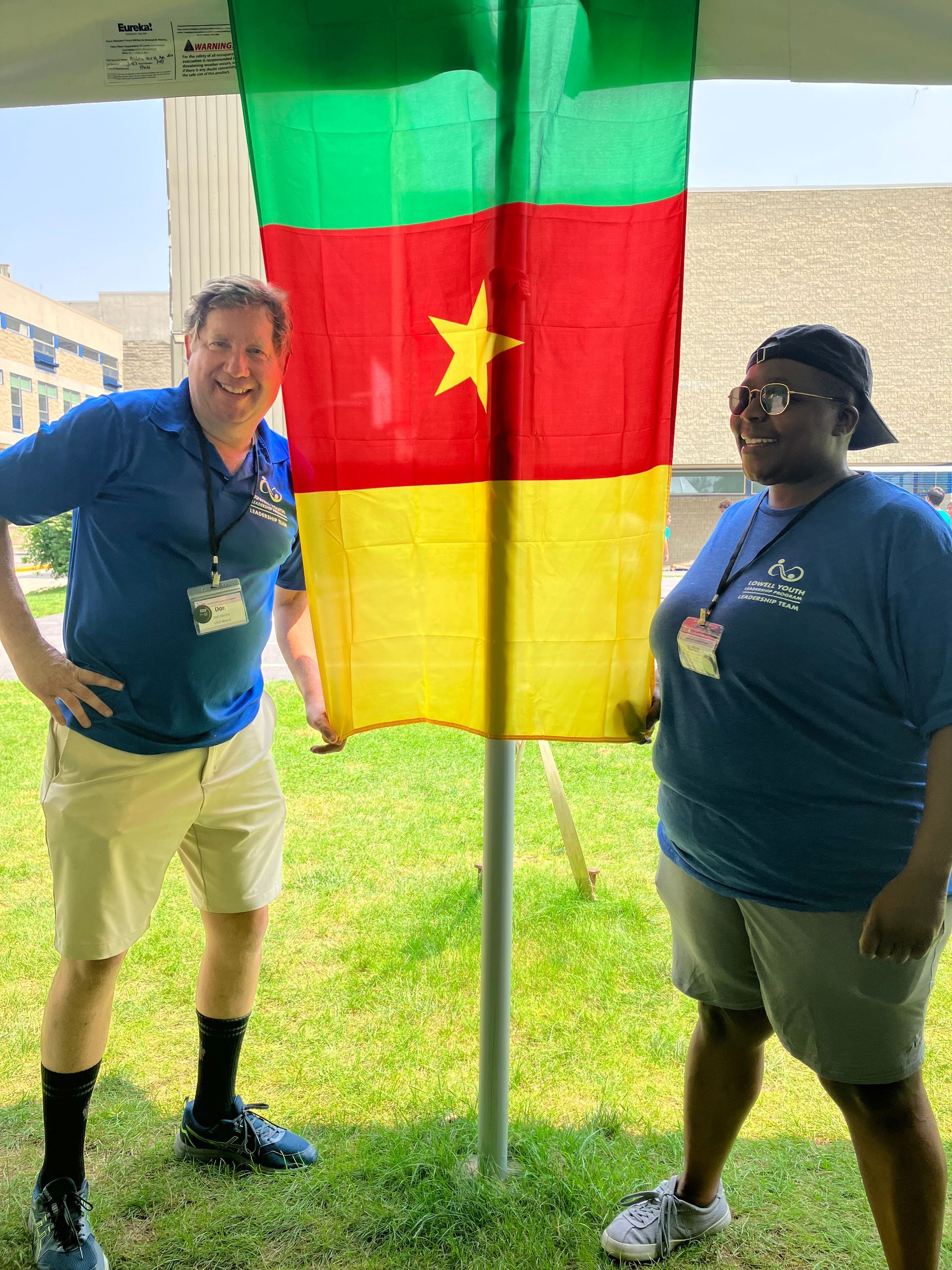 A man and a woman standing in front of a flag