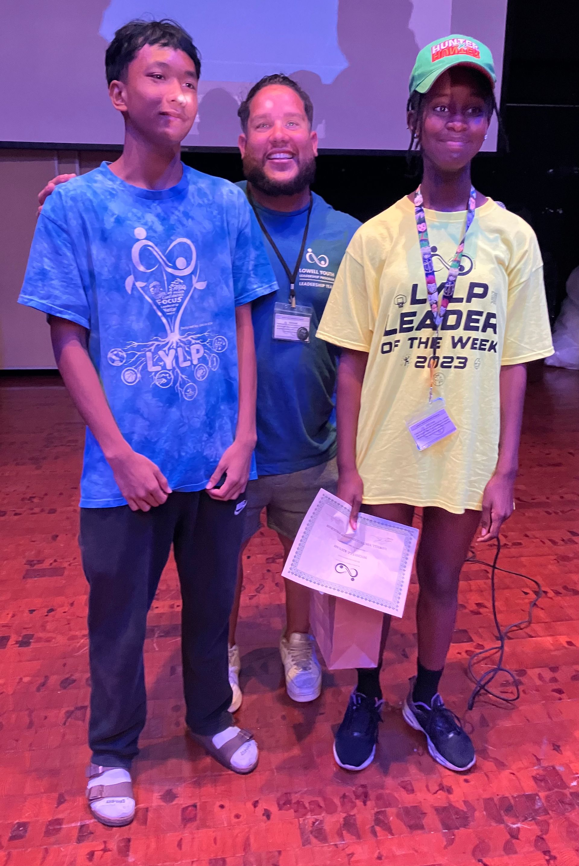 A man and two children are standing next to each other on a stage.