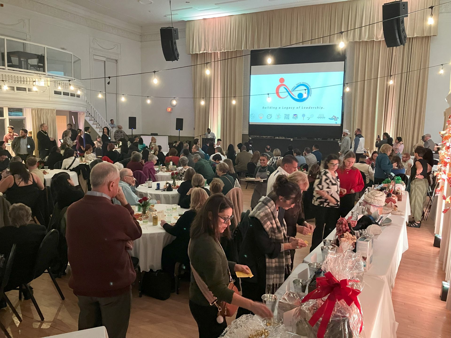 A large group of people are sitting at tables in a large room.