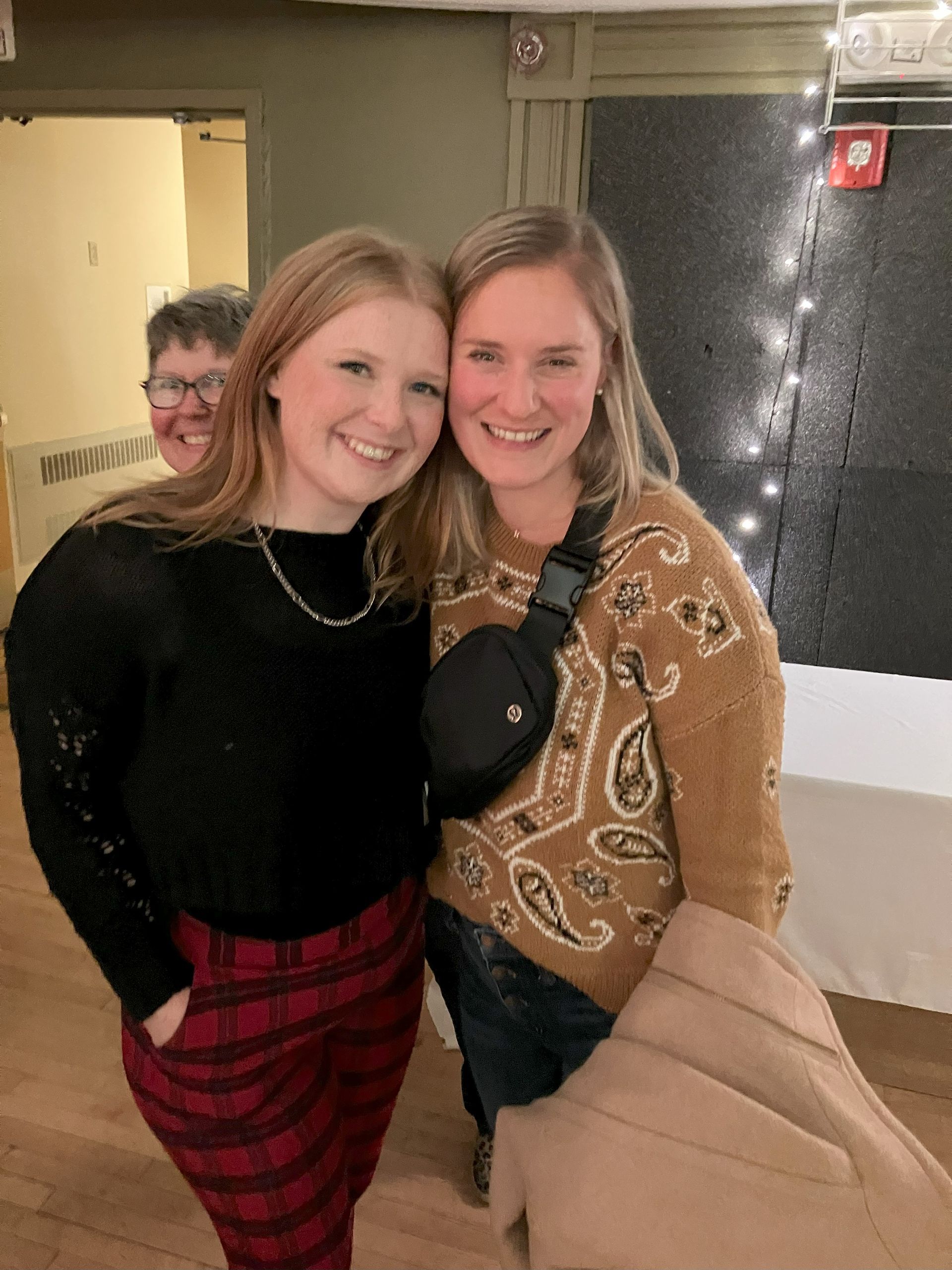 Two women are posing for a picture together in a room.