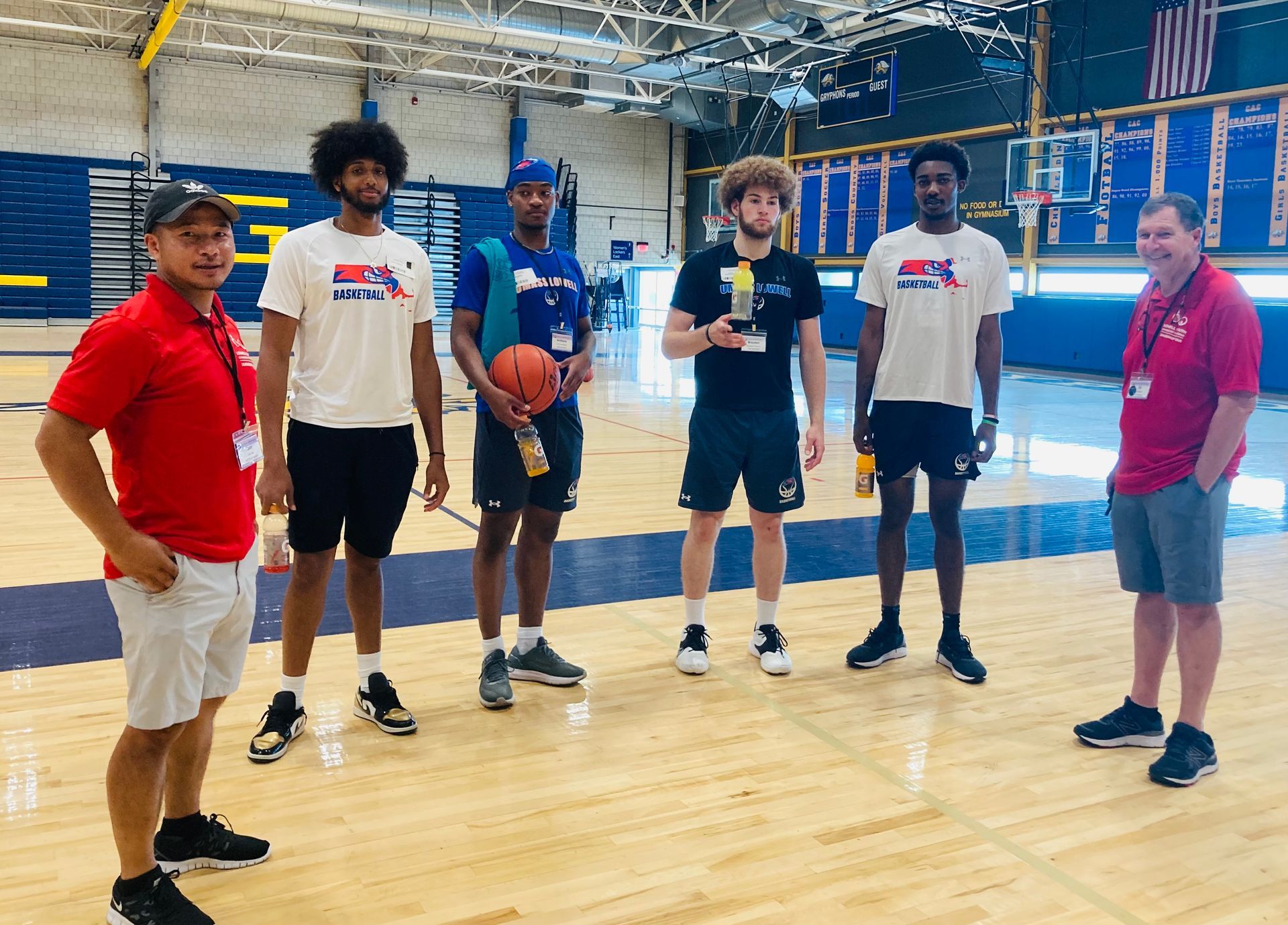 A group of men are standing on a basketball court.