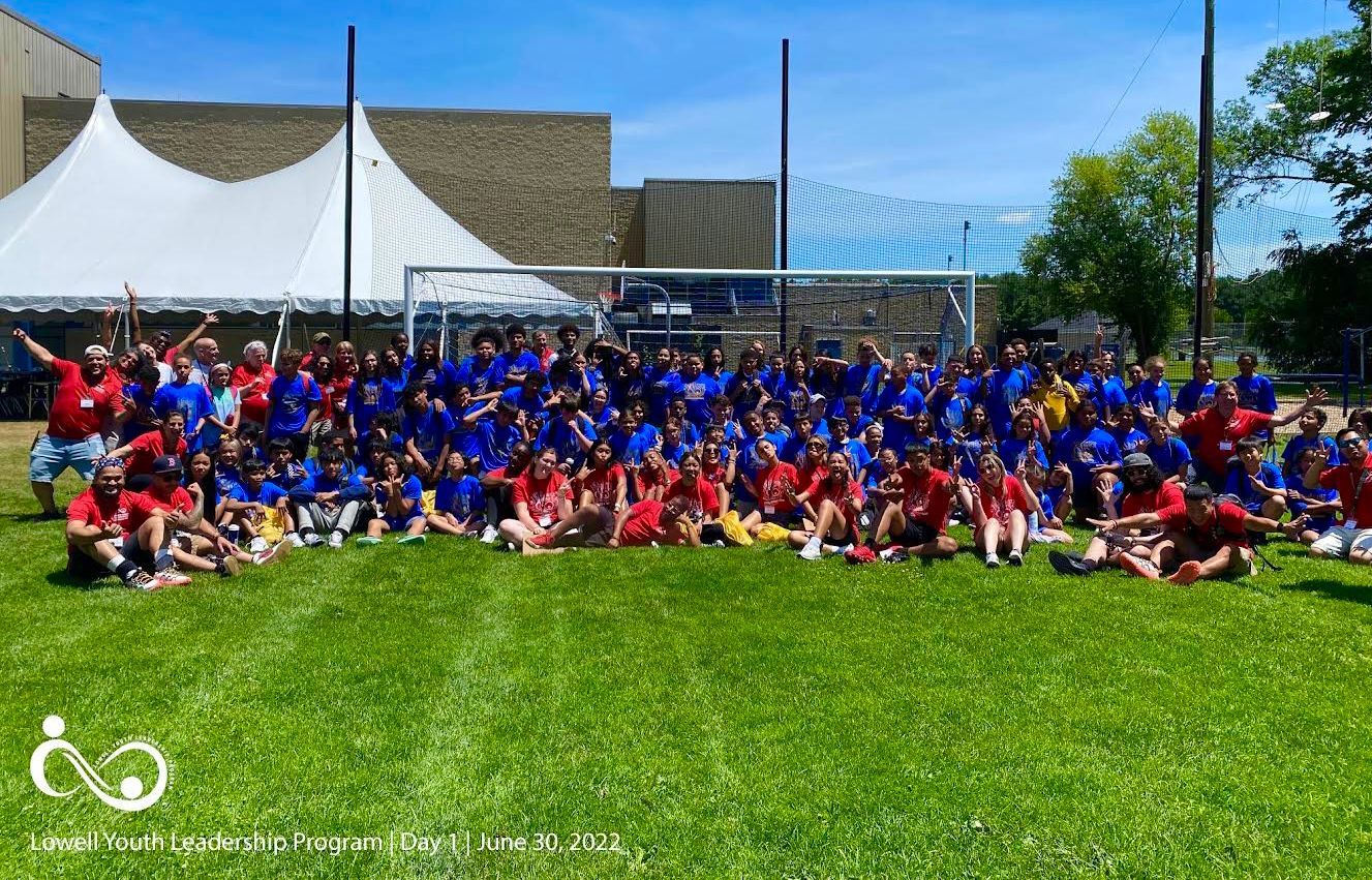 A large group of people are posing for a picture on a soccer field.