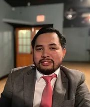 A man with a beard is wearing a suit and tie.