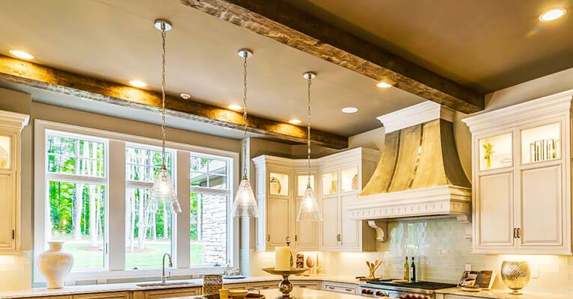 Kitchen with high quality steel I beam ceiling box beam covers made from reclaimed wood and hand hewn