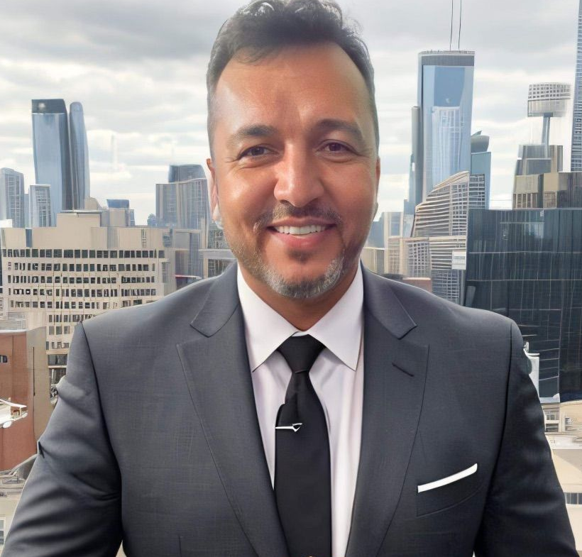 Man in a suit smiles, adjusting jacket, cityscape background.