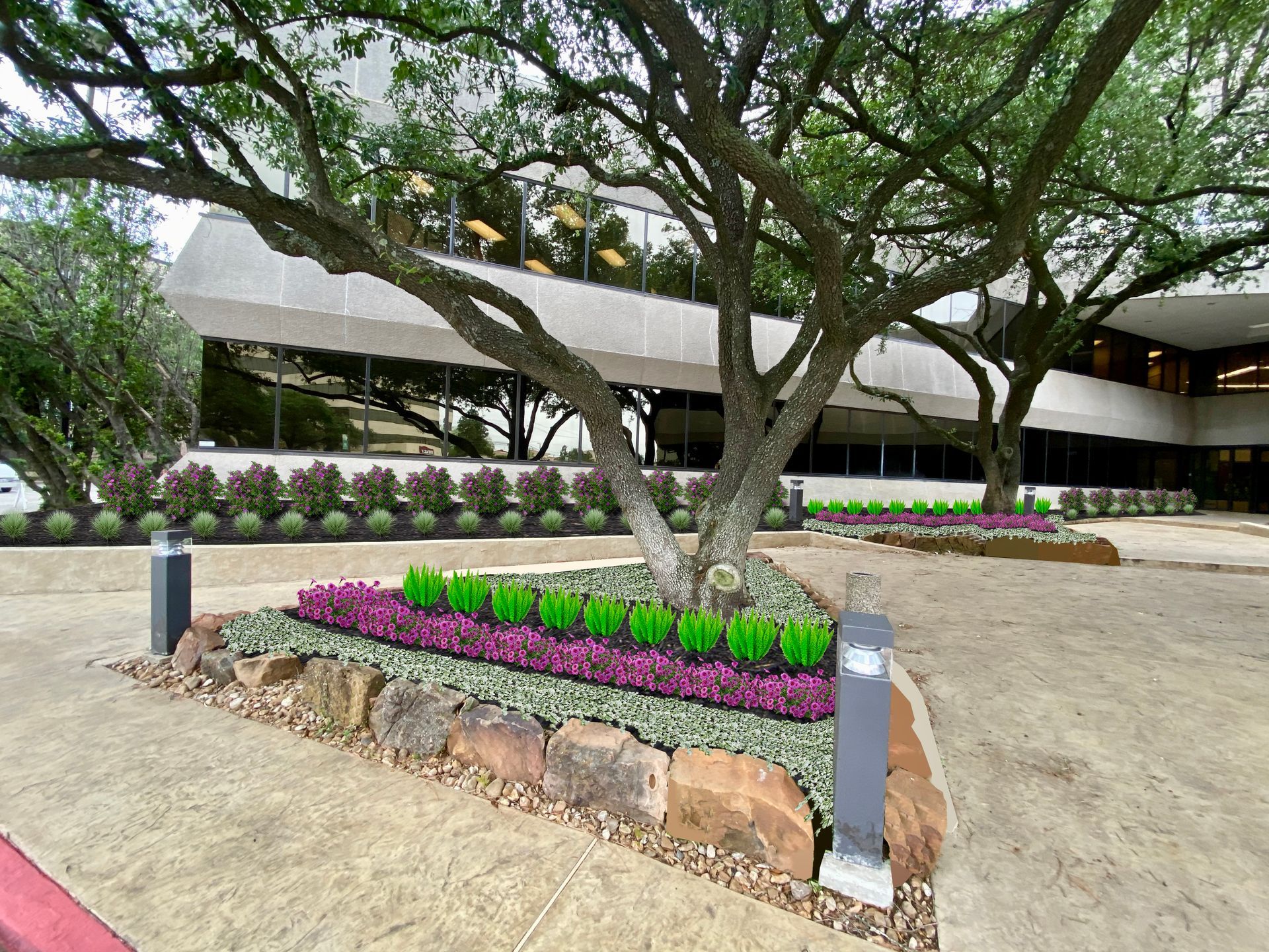 Landscaped entrance with trees, flower beds, and a low-rise building in the background.