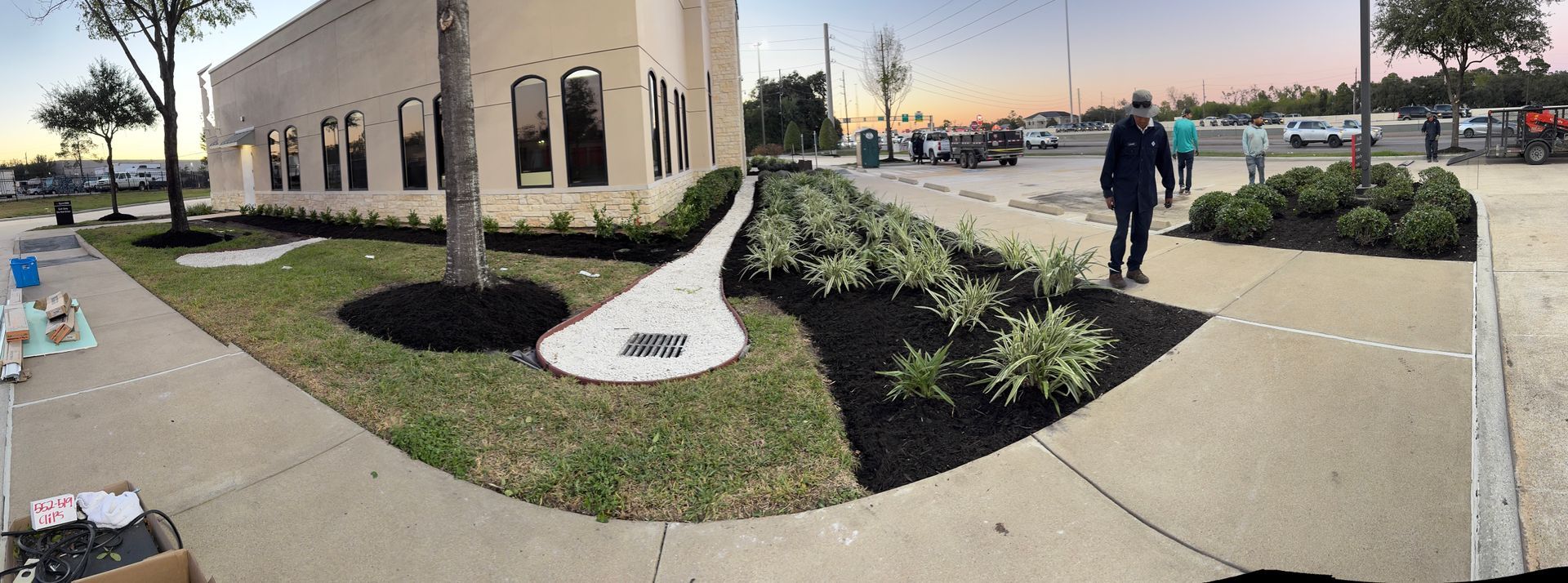 Exterior view of a building with people walking on a sidewalk and parking lot in the background.