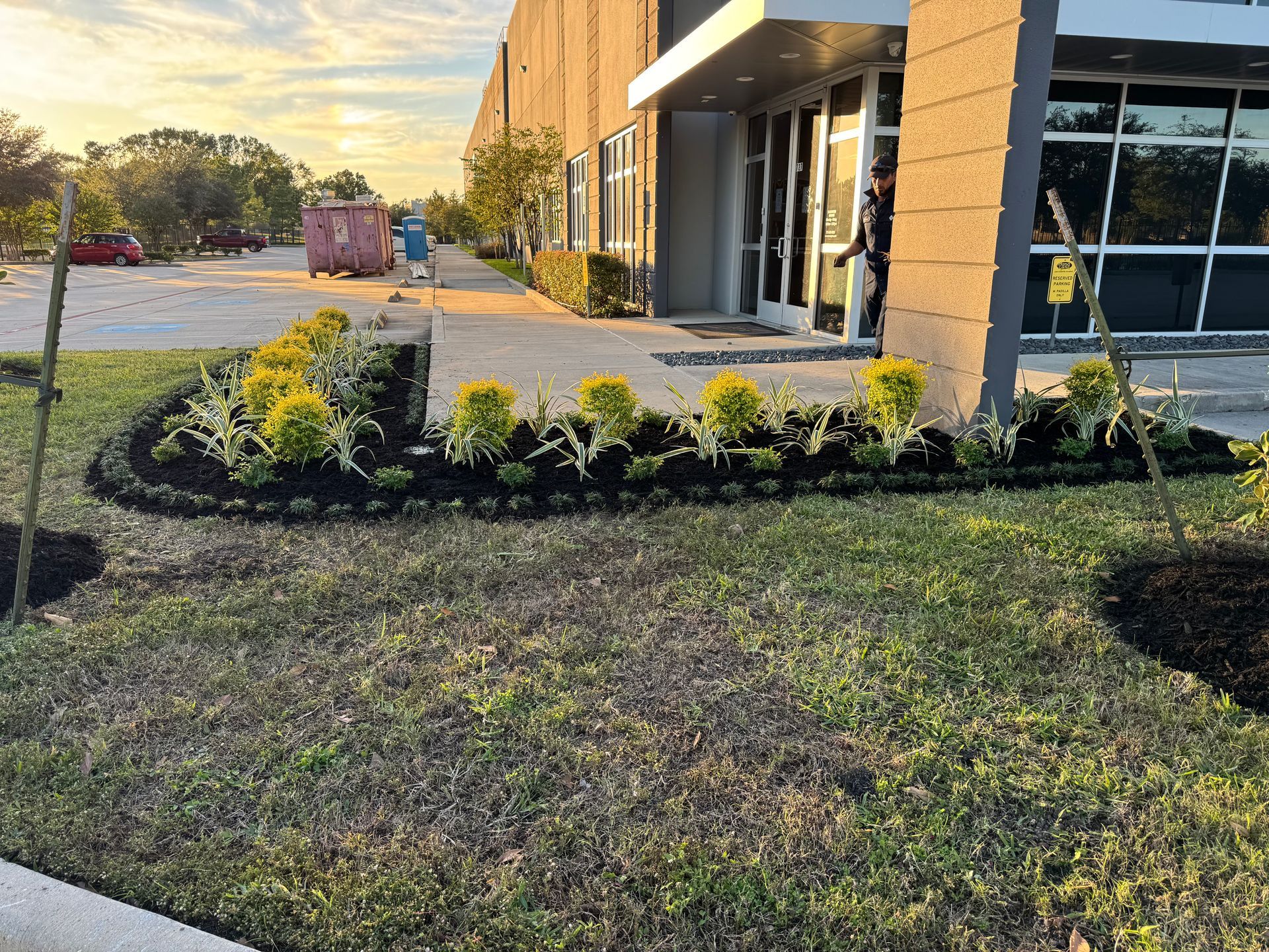 Exterior of a modern building with landscaping and a person near the entrance.