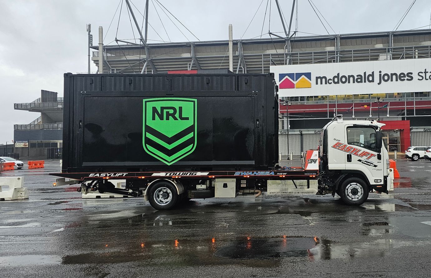 A Large White Truck Is Parked in A Grassy Field — Easylift Towing NSW Pty Ltd In Swansea, QLD