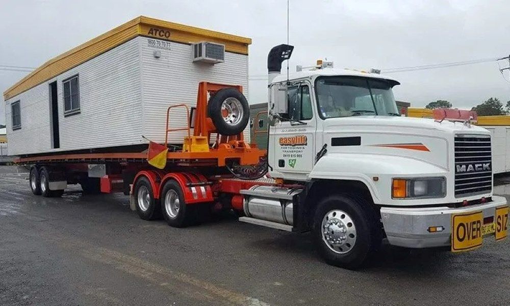 A Mack Truck Is Pulling a Trailer with A Container on It — Easylift Towing NSW Pty Ltd In Cessnock, QLD