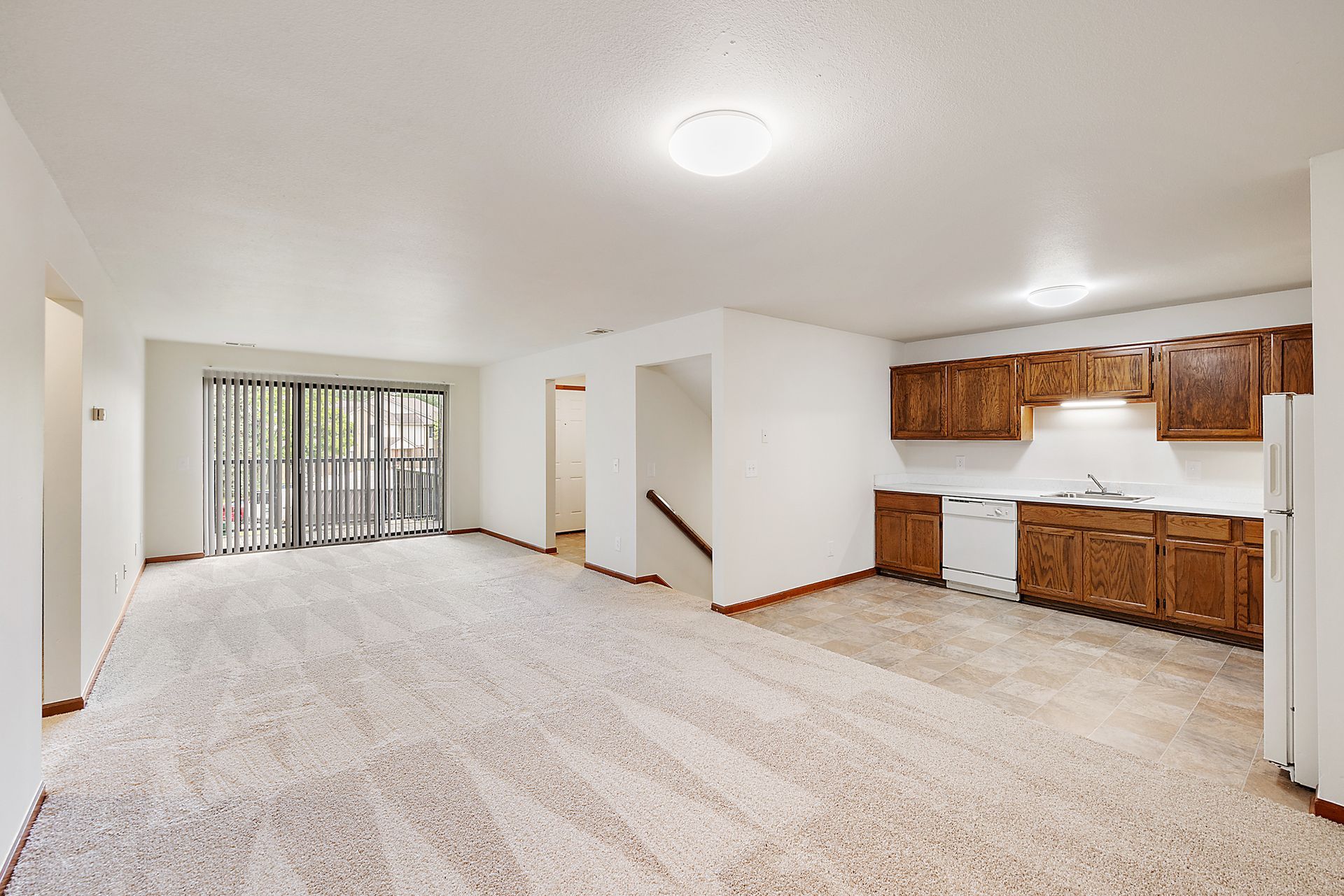 An empty apartment with a kitchen and a living room