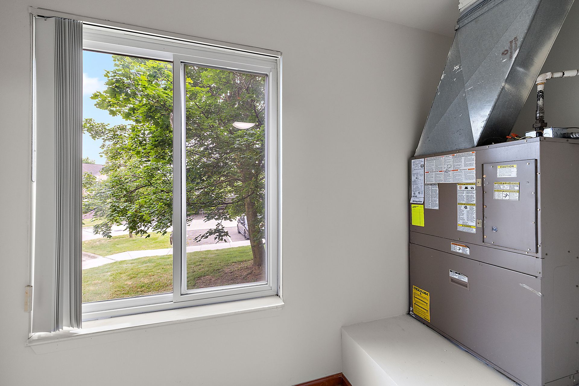 A room with a window and a furnace in it.