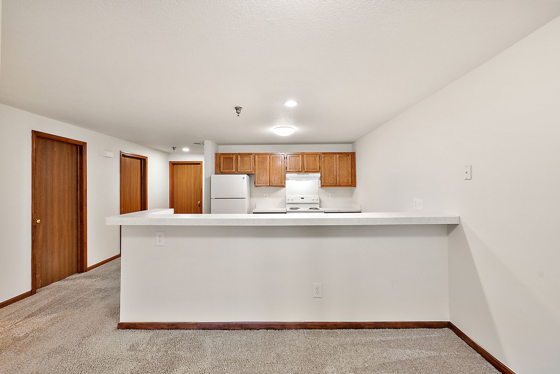 An empty apartment with a kitchen and a counter