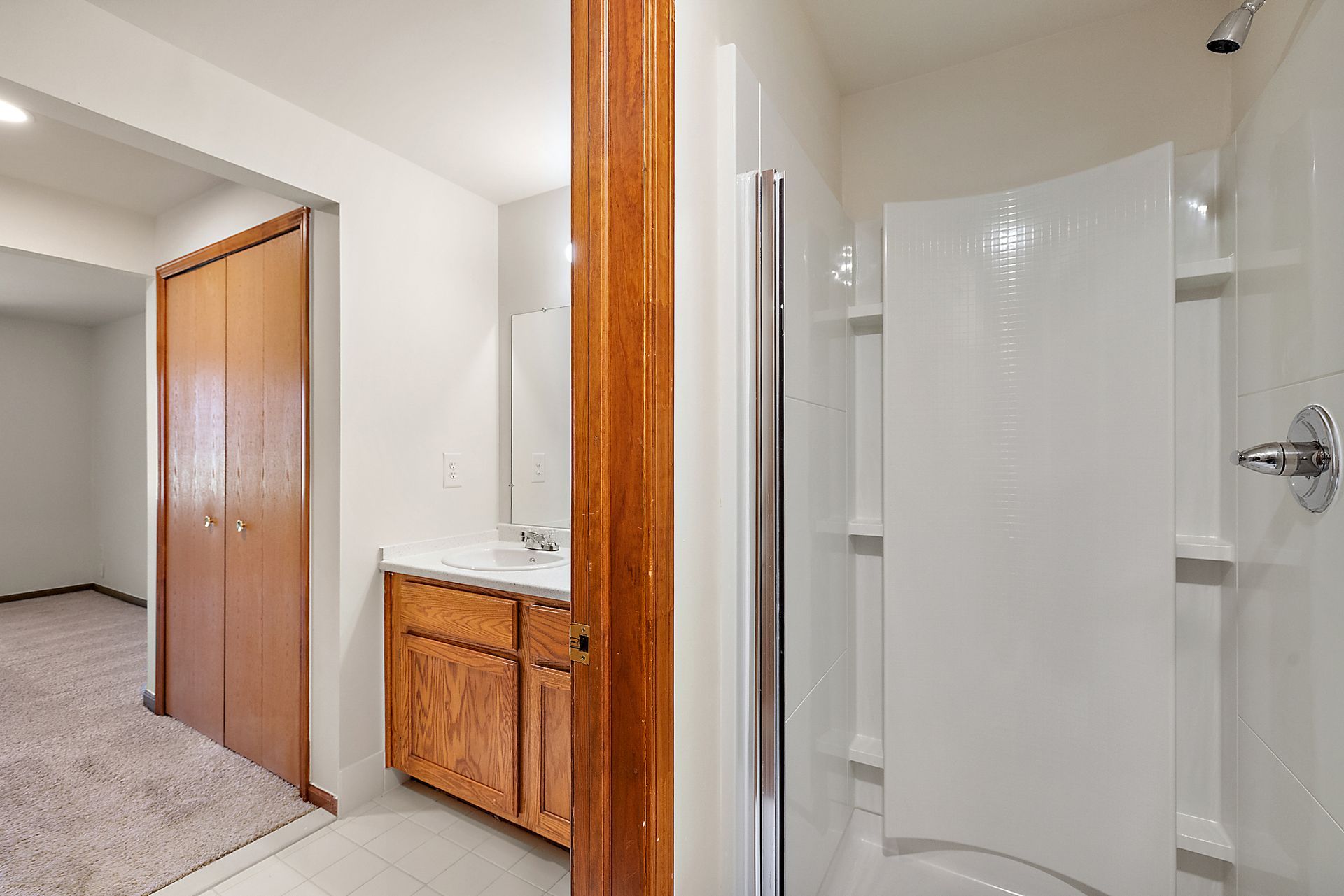 A bathroom with a sink and a walk in shower.