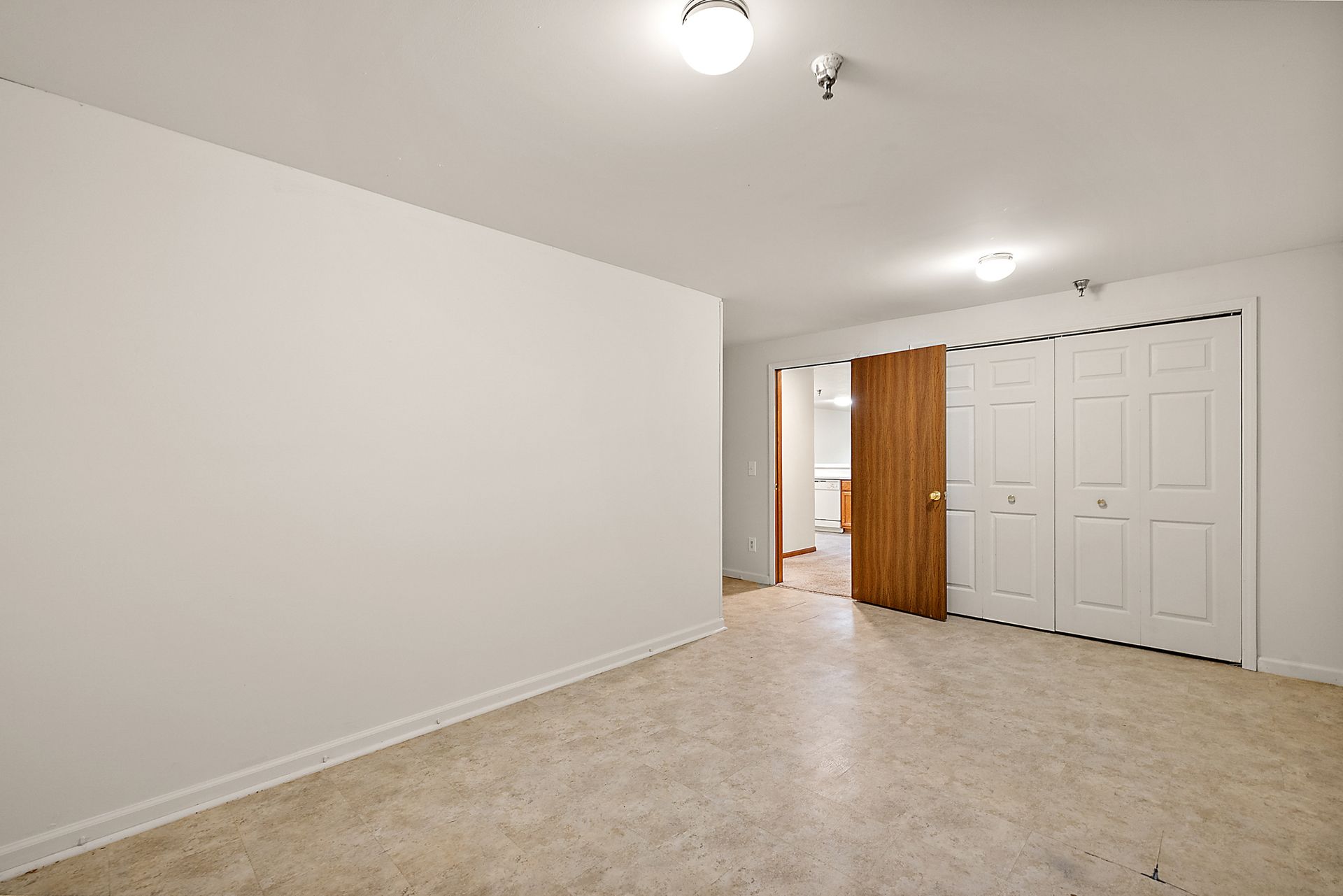 An empty room with white walls and a wooden door.
