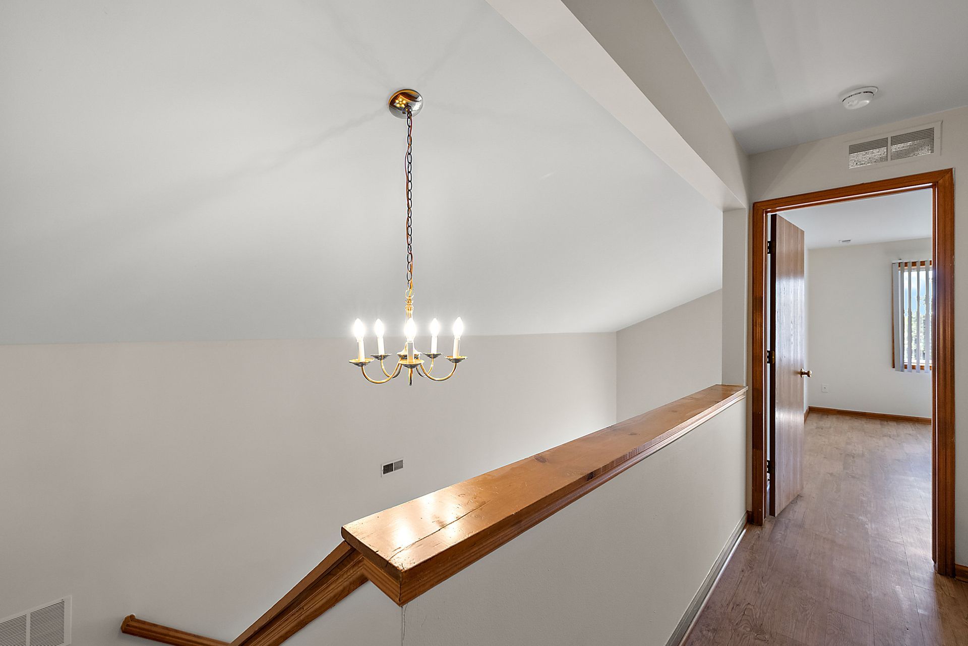 A staircase with a chandelier hanging from the ceiling